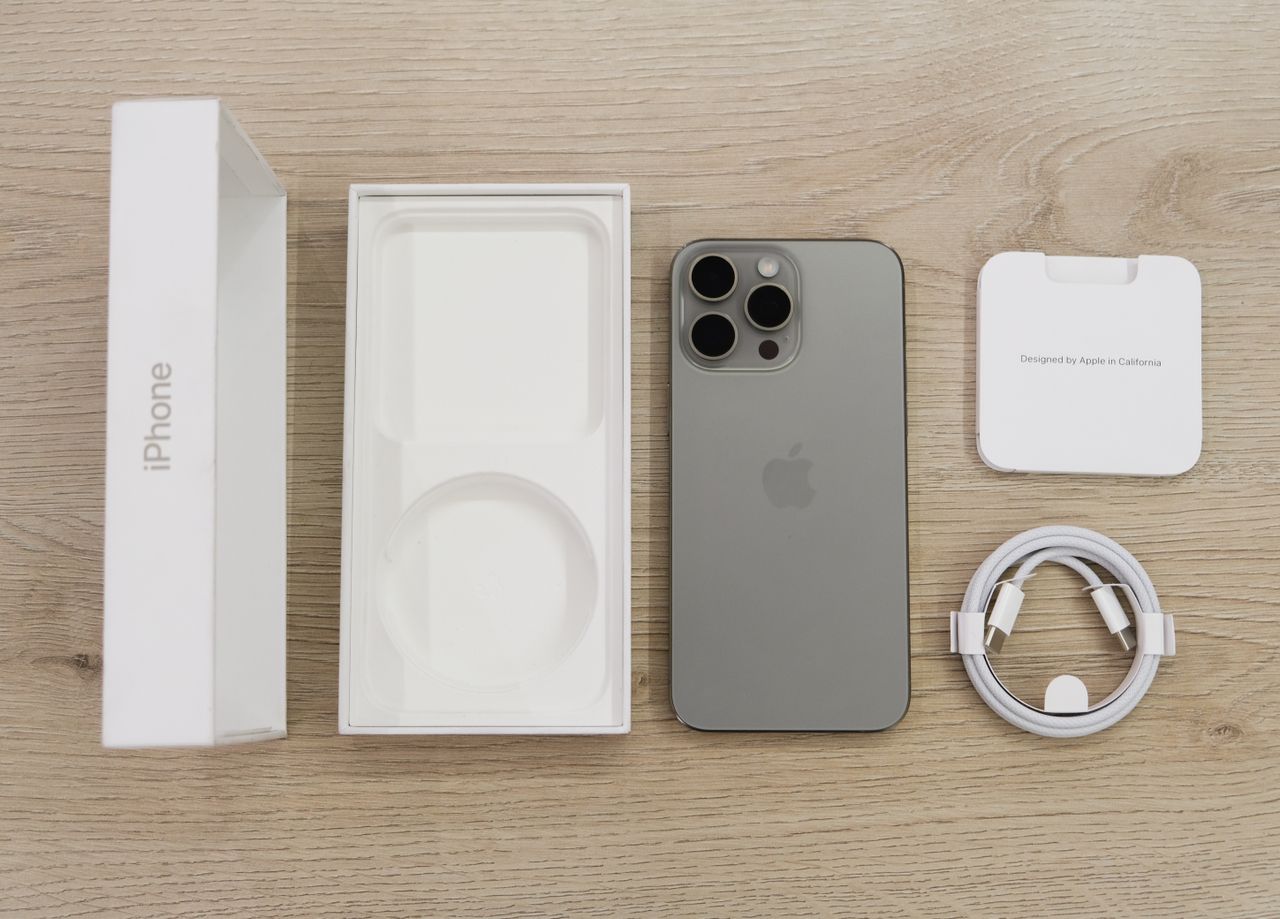 箱とケーブルなど付属品をそろえたiPhone